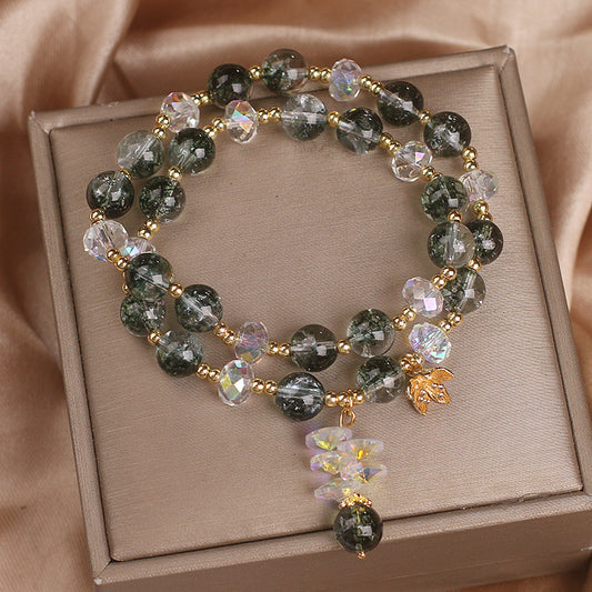 Green crystal flower charm bracelet with botanical pendant on white background