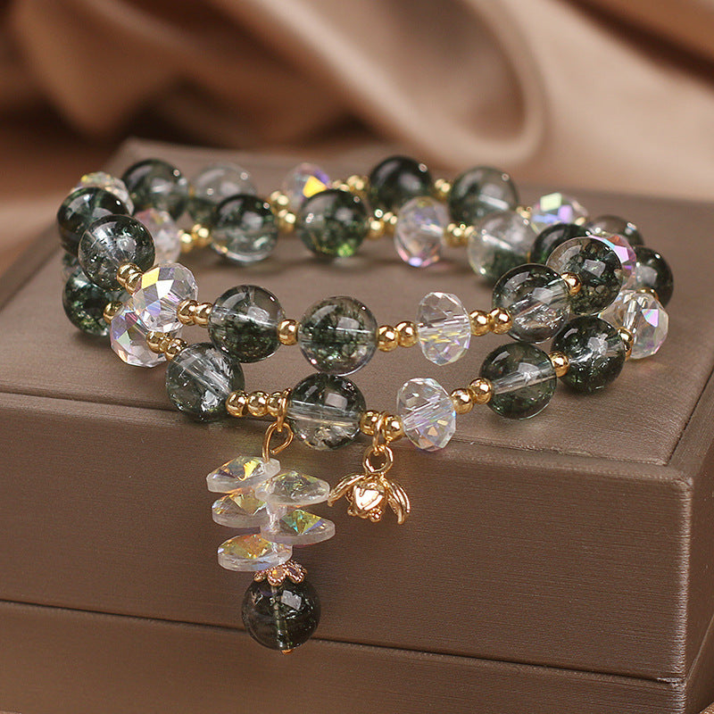 Detailed view of flower pendant charm on green crystal bracelet