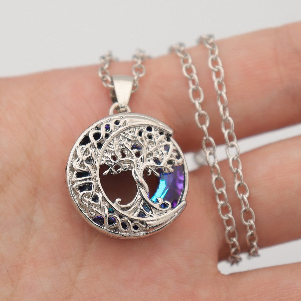 Blue chain necklace with moon and tree symbols lifestyle shot